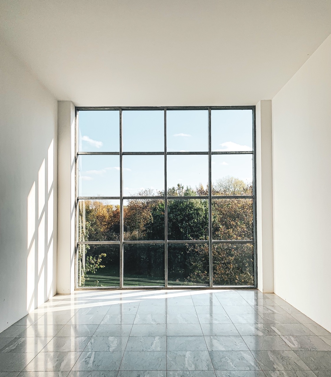 Desk with leather desk pad, walnut desk organizer, wireless keyboard and mouse, and porcelain mug.